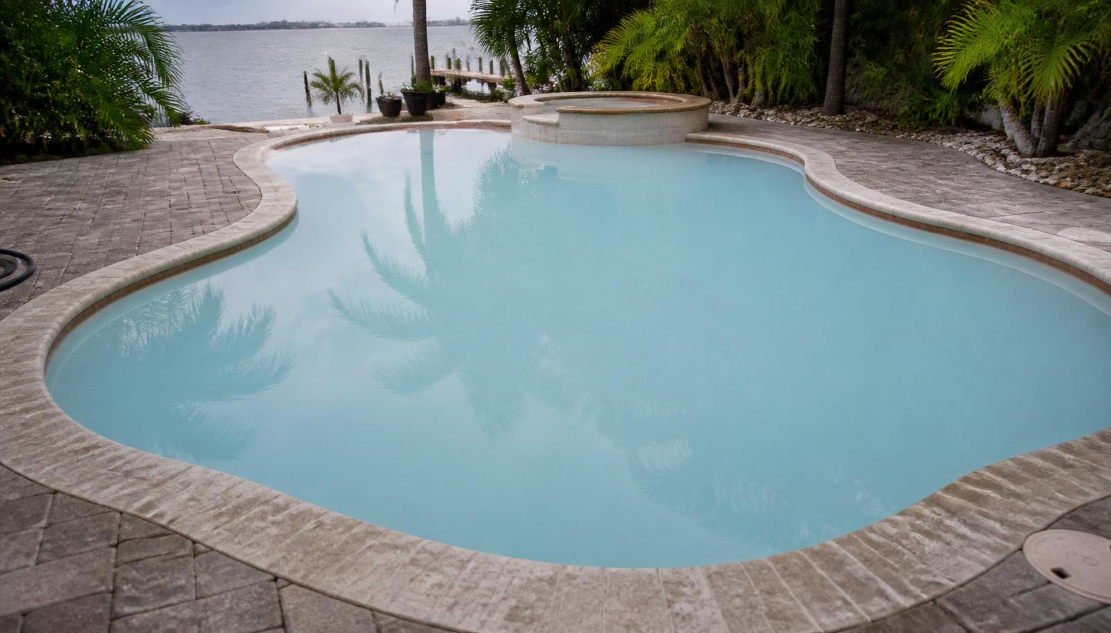 Milky cloudy water in a residential Florida pool with a paver deck