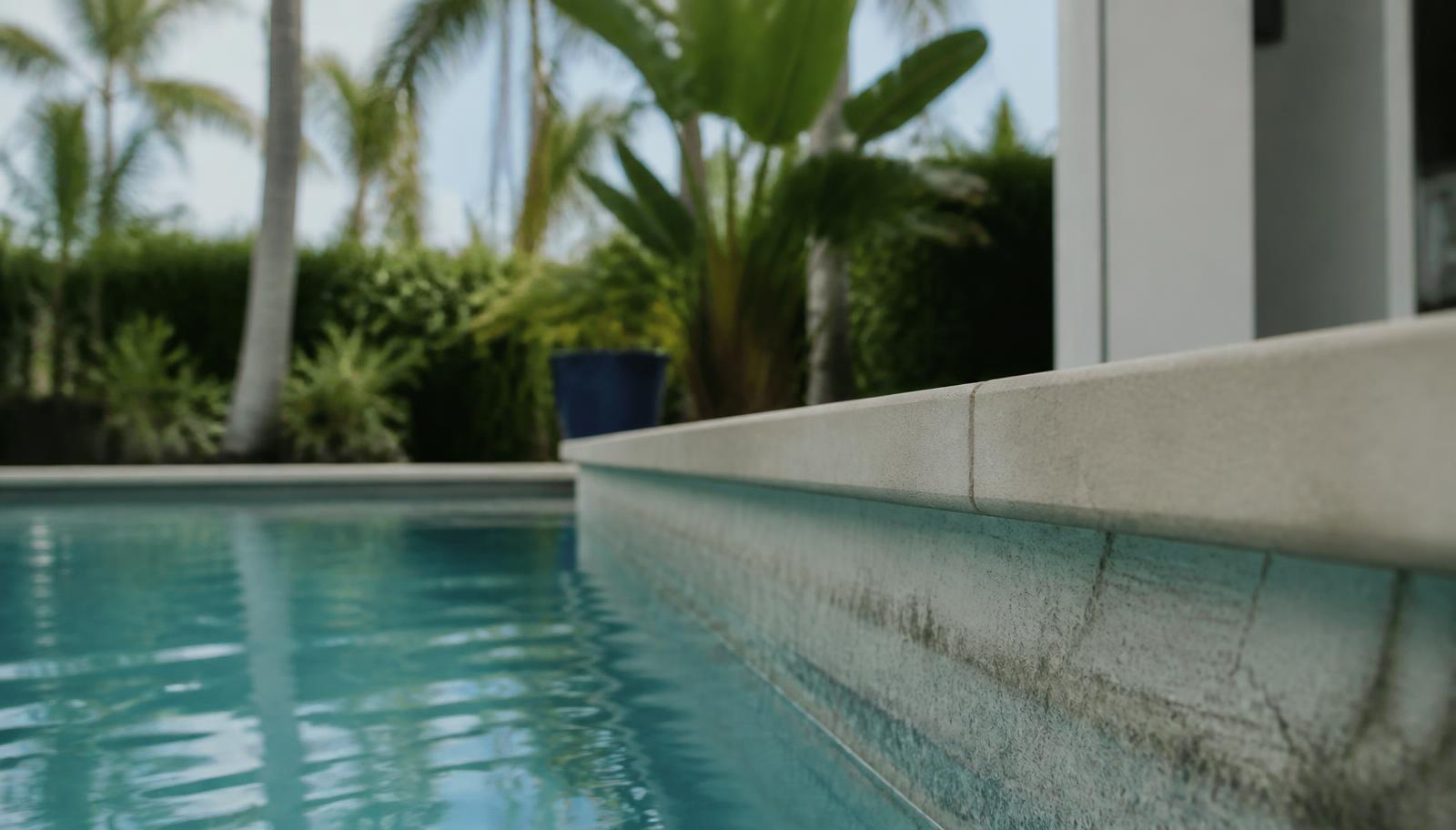 Waterline of a residential Florida pool with a low water level along the coping edge