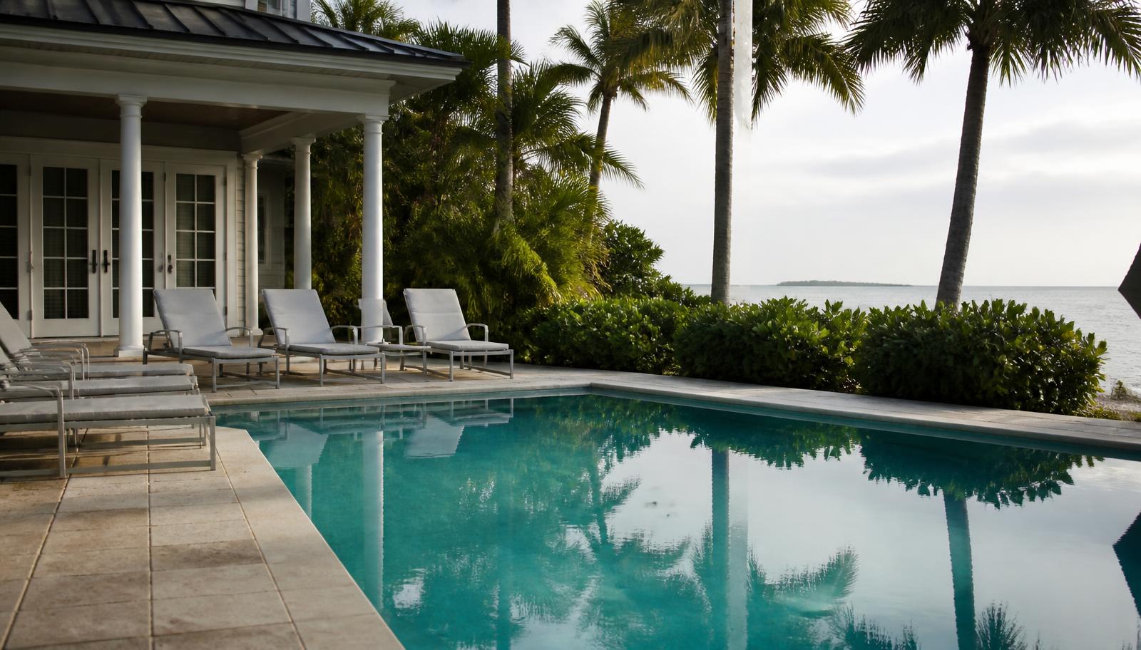 Quiet residential Florida pool at a closed-up seasonal home on a bright morning